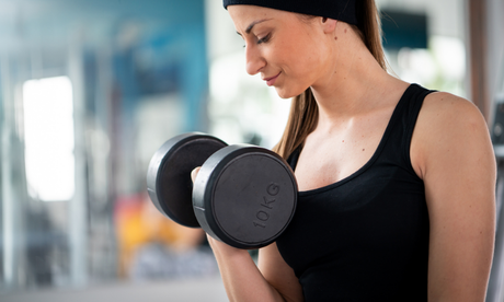 young female working out at home with dumbbells