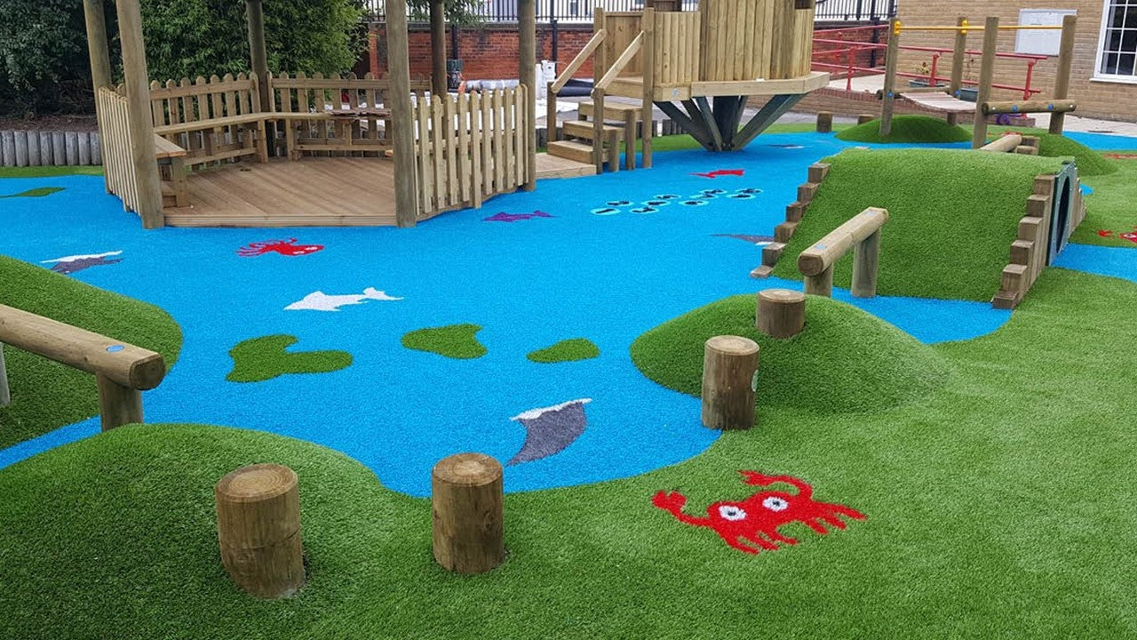 Kids play area with trim trail with blue and green play grass.