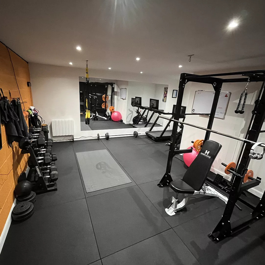 Home gym with squat rack and bench on black 20mm PRO rubber gym tiles