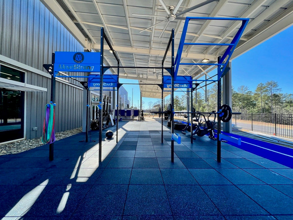 Outdoor functional area with rubber gym tiles and blue outdoor sprint track