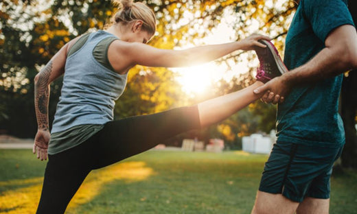 female exercising with personal training outdoors
