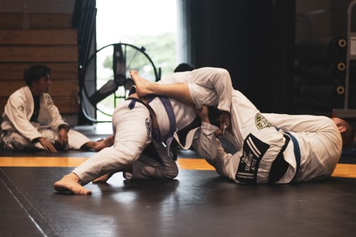 Two men grappling on martial arts flooring