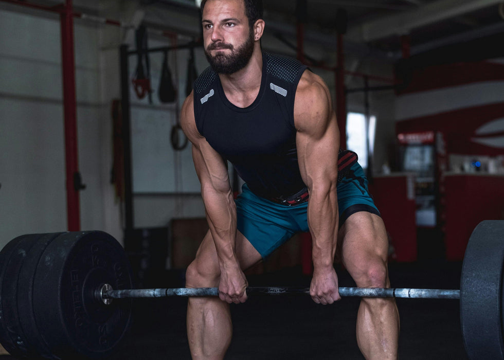 Man lifting a barbell on gym flooring